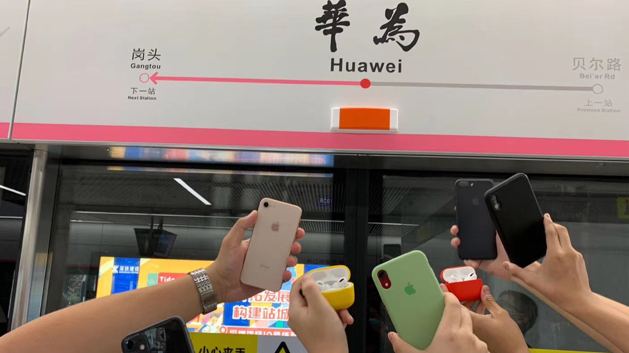 Apple fans posing in train station named after Huawei